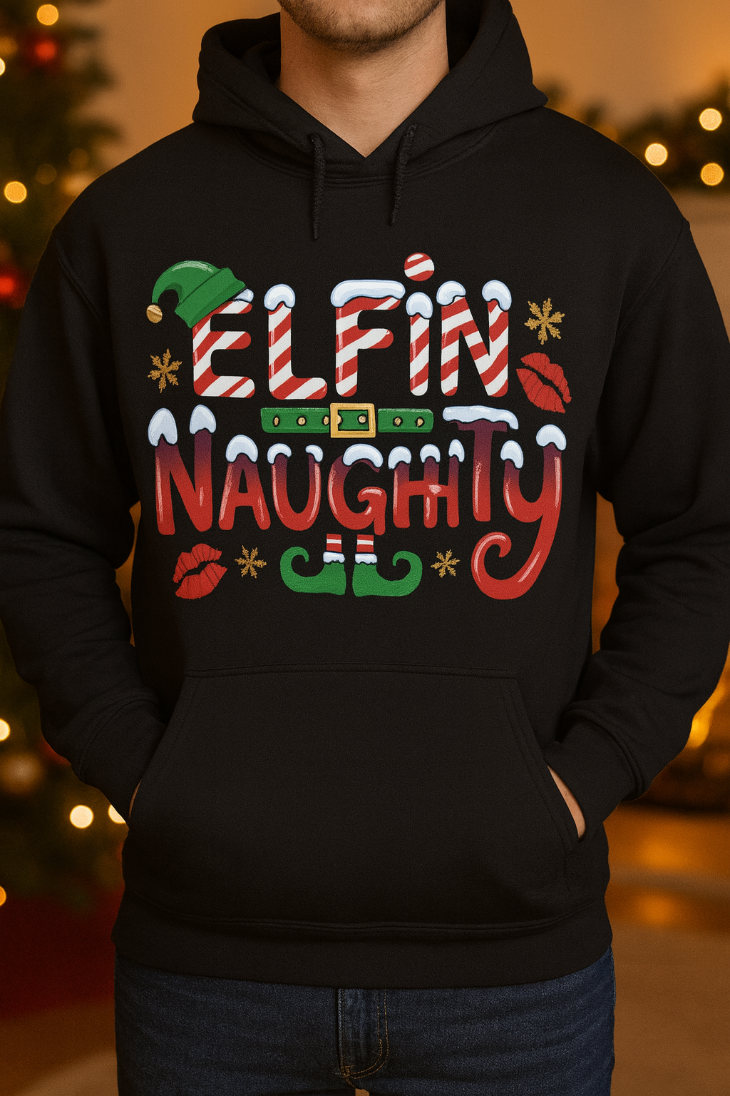 Black hoodie with 'Elfin Naughty' text and festive graphics on a blurred Christmas background