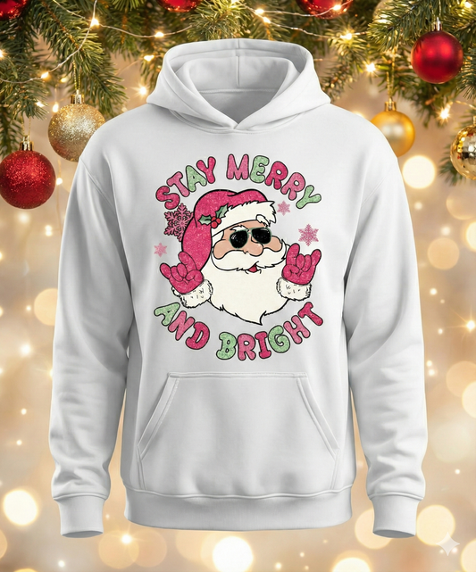 White hoodie with Santa Claus graphic and 'Stay Merry and Bright' text on a festive background.