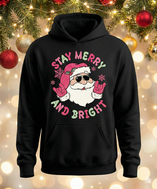 Black hoodie with Santa Claus graphic and 'Stay Merry and Bright' text against a festive background.