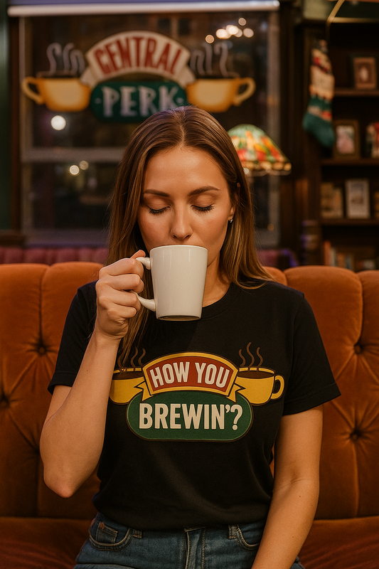 Black t-shirt with “How You Brewin’?” text and yellow coffee cups design – perfect for coffee drinkers and baristas