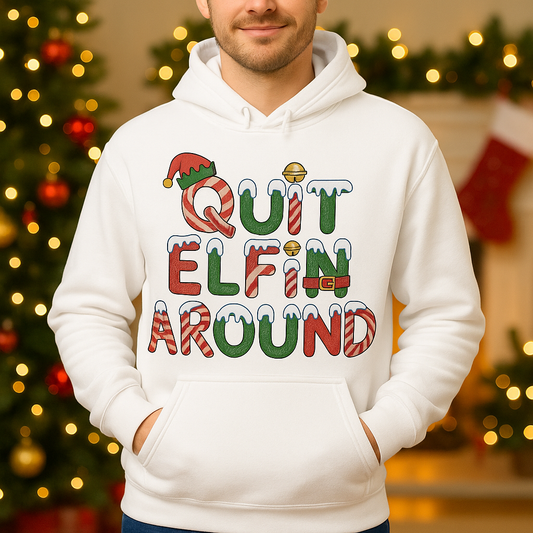 Person wearing a white hoodie with Christmas-themed text in a festive setting.